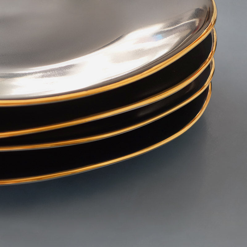 détail d'une pile d'assiettes noires avec rebords or