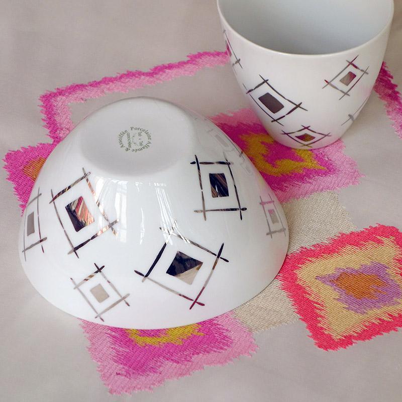 bol blanc à motifs argentés retourné sur une nappe blanche et rose fluo - tsé tsé