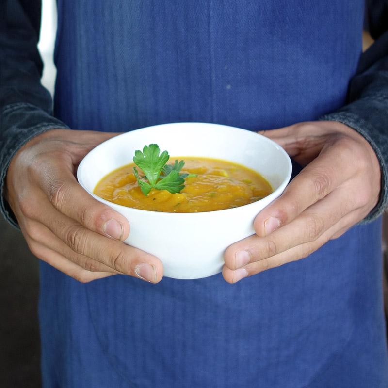 bol en porcelaine de forme irrégulière rempli de soupe et tenu en main - tsé tsé