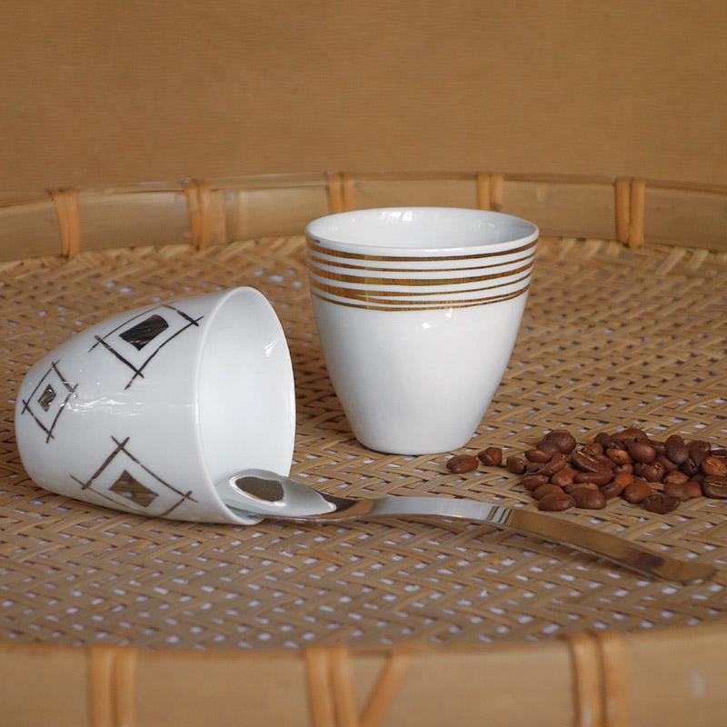 duo de tasses or et argent sur un plateau avec cannage et grains de café - tsé tsé