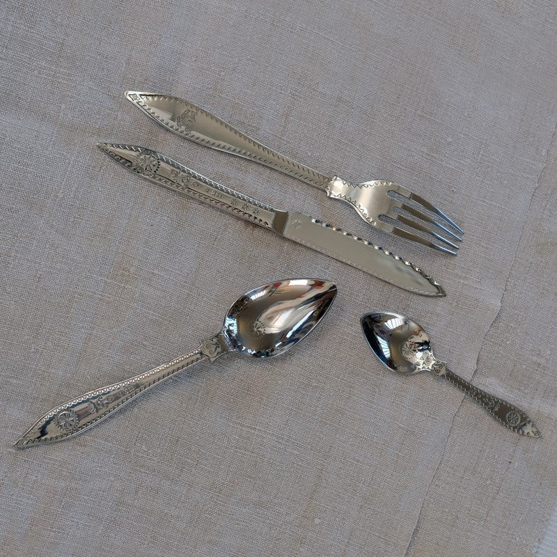 set de couverts de table en acier inoxydable avec manche poinçonné posés sur une nappe blanche - tsé tsé