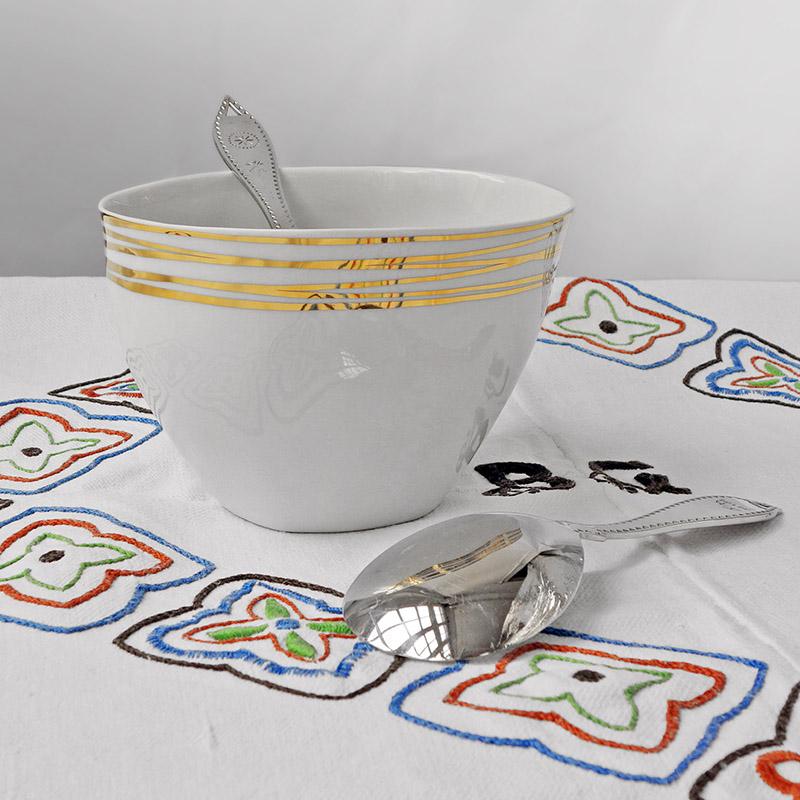saladier en porcelaine blanche et or posé sur une nappe blanche brodée - tsé tsé