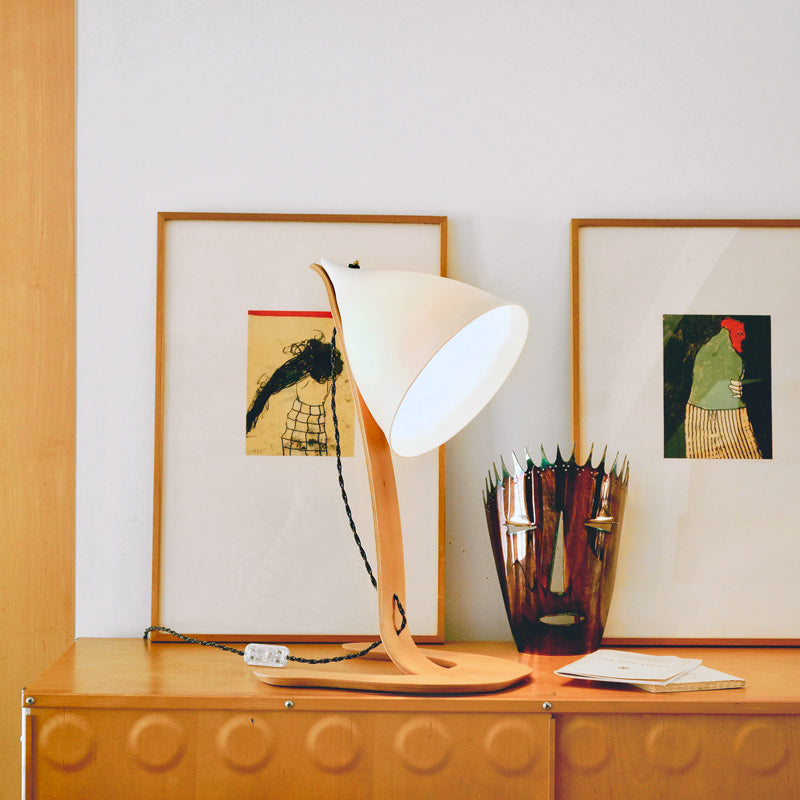 lampe sur pied en porcelaine mate posée sur un buffet devant des tableaux et un masque en métal - tsé tsé