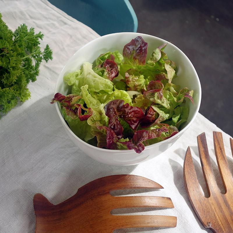 grand bol blanc rempli de salade verte vu d'en haut et couverts à salade en bois - tsé tsé