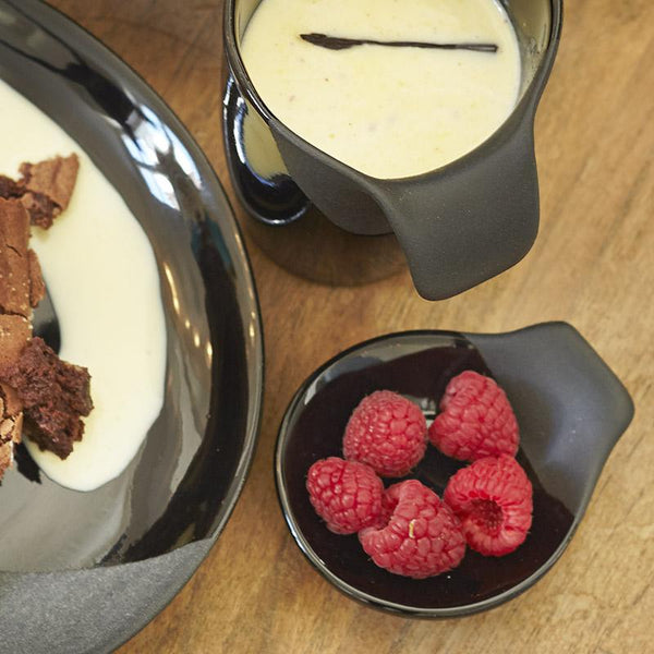 mini soucoupe noire asymétrique et partiellement mate avec des framboises dedans, assiette et tasse assorties - tsé tsé