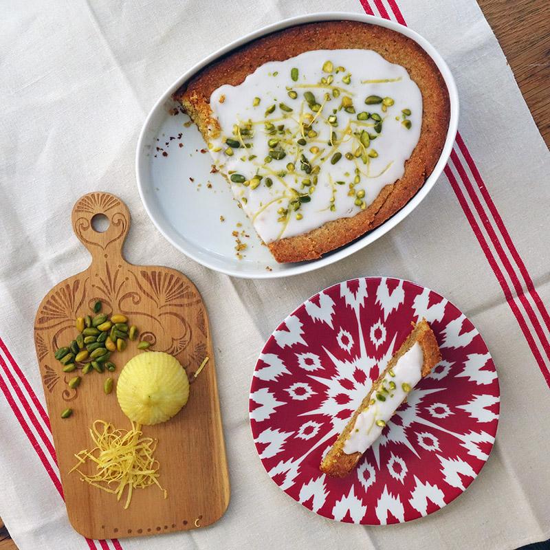 gateau citron pistache dans un moule de forme irrégulière avec une petite planche à décuper et une assiette rouge à motif ouzbek - tsé tsé