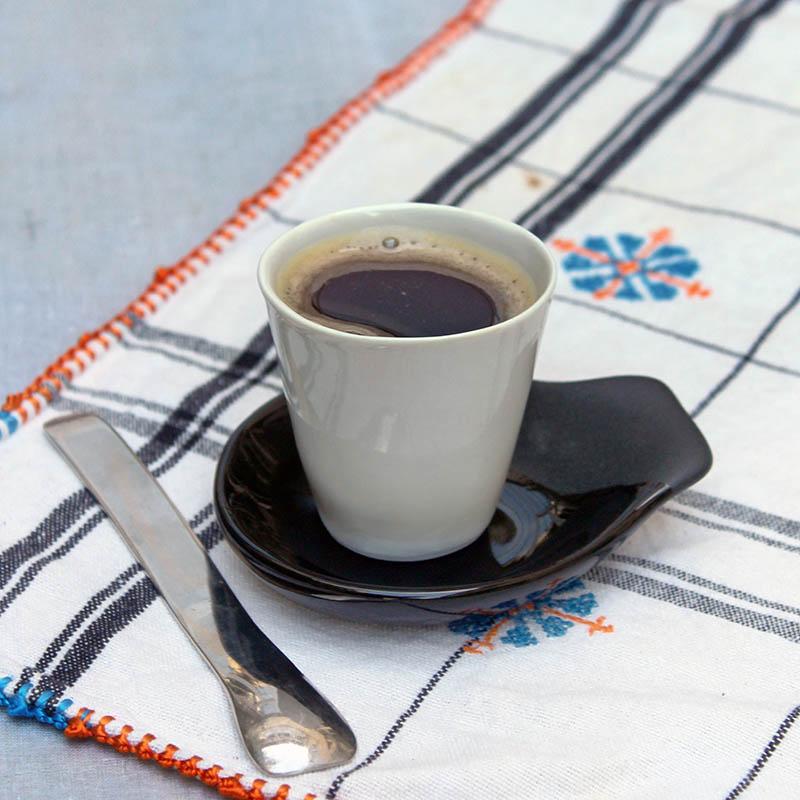 tasse à expresso posée sur une petite soucoupe noire asymétrique  - tsé tsé