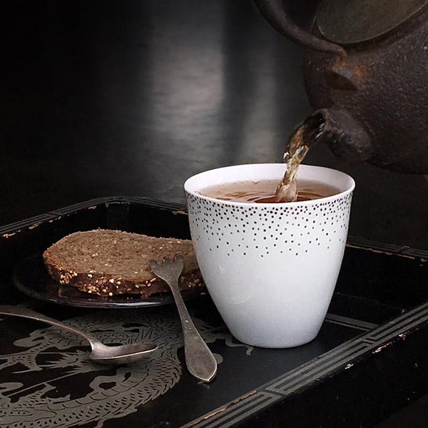 grande tasse à thé blanche avec confettis argentés, tranche de pain et théière en fonte - tsé tsé
