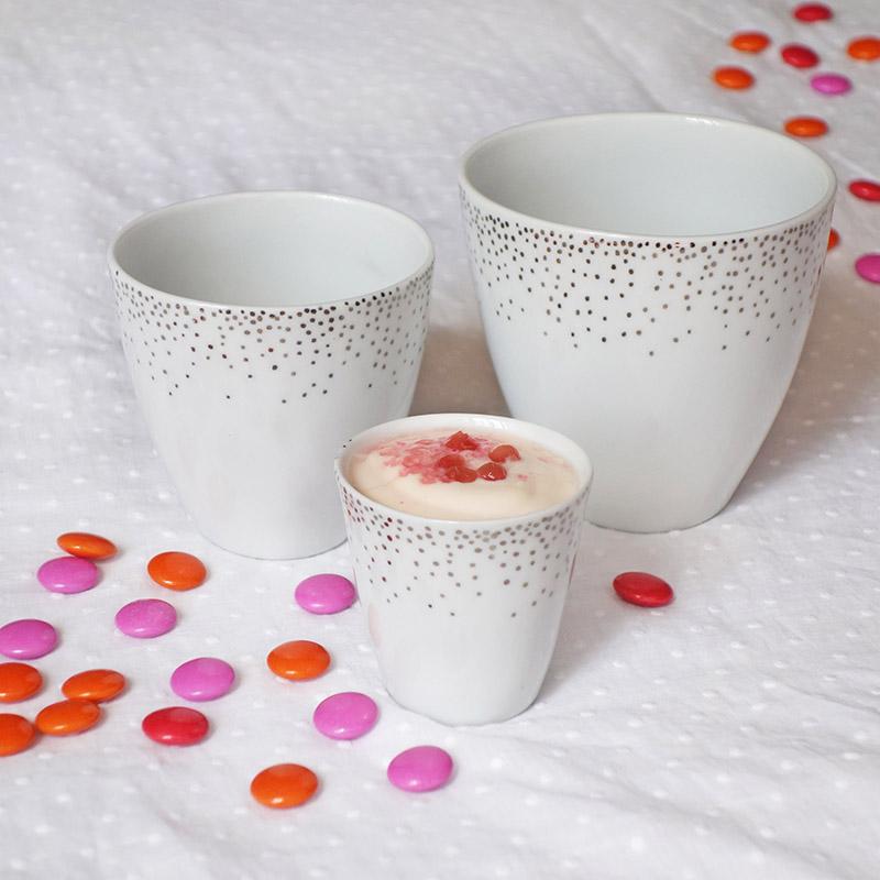 tasses sans poignée blanches et argentées de trois tailles différentes à coté de smarties rose et orange - tsé tsé