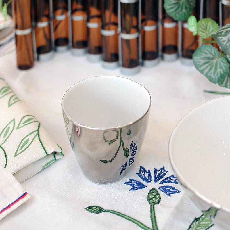 tasse blanc et argent sur table avec une nappe brodée - tsé tsé