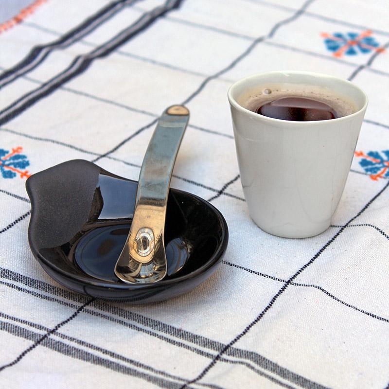 gobelet à expresso blanc et cuillère à café avec le manche ondulé dnas une soucoupe asymétrique noire - tsé tsé