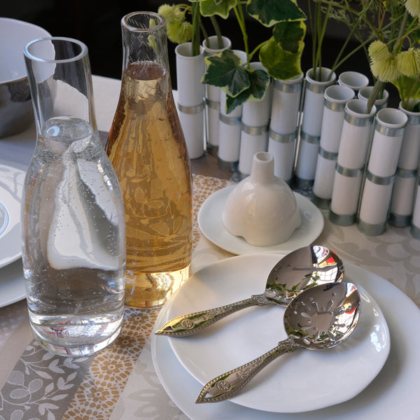 Table de repas avec vaisselle, couverts de service et vase avec des tubes en porcelaine