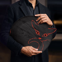 Plateau en bois noir avec silhouette de chat orange vif, tenu par une homme