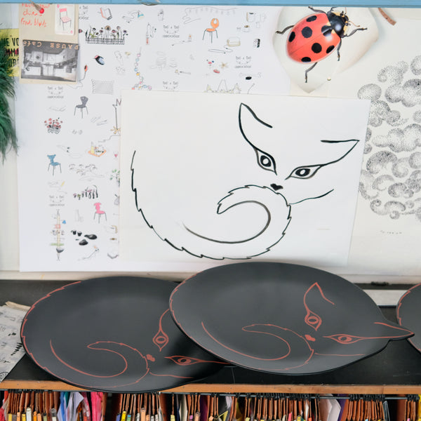 dessin léger d'une silhouette de chat, sur papier et sur plateaux en bois