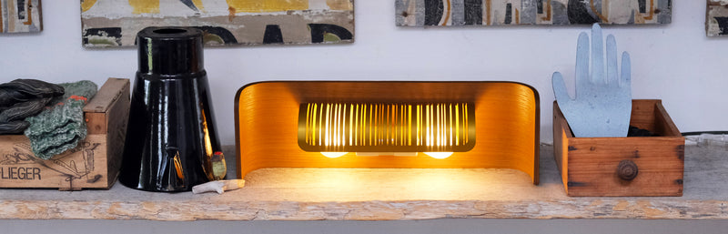 Lampe design en bois courbé posée sur une étagère