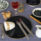 assiette noir bleuté avec un liseré or et tasse blanche à motif spirale dorée - tsé tsé