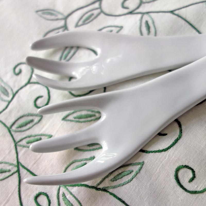 zoom sur les fourchettes à salade en porcelaine blanche posés sur une nappe avec une broderie verte - tsé tsé