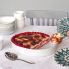 plat à gratin ou à gâteau de forme irrégulière et piles de vaisselle blanche et colorée - tsé tsé