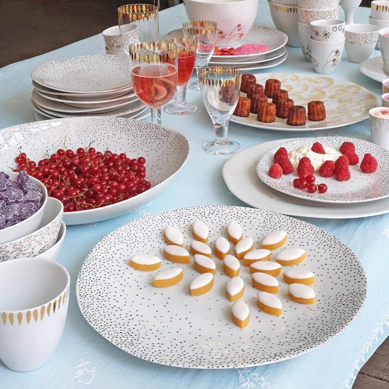 table de fête dressée avec de la vaisselle en porcelaine blanche ornée de pois argentés - tsé tsé