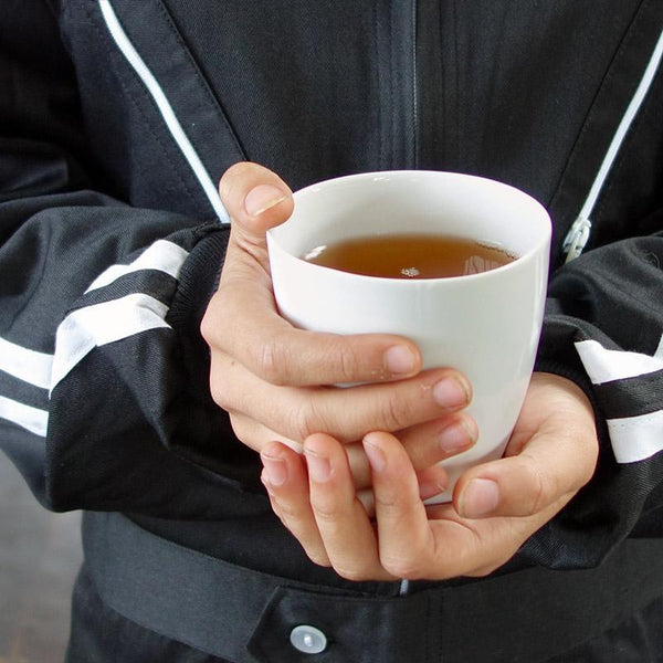 tasse à thé sans poignée en porcelaine irrégulière tenue en main - tsé tsé