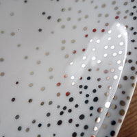 détails confettis en platine sur assiette blanche en porcelaine - tsé tsé
