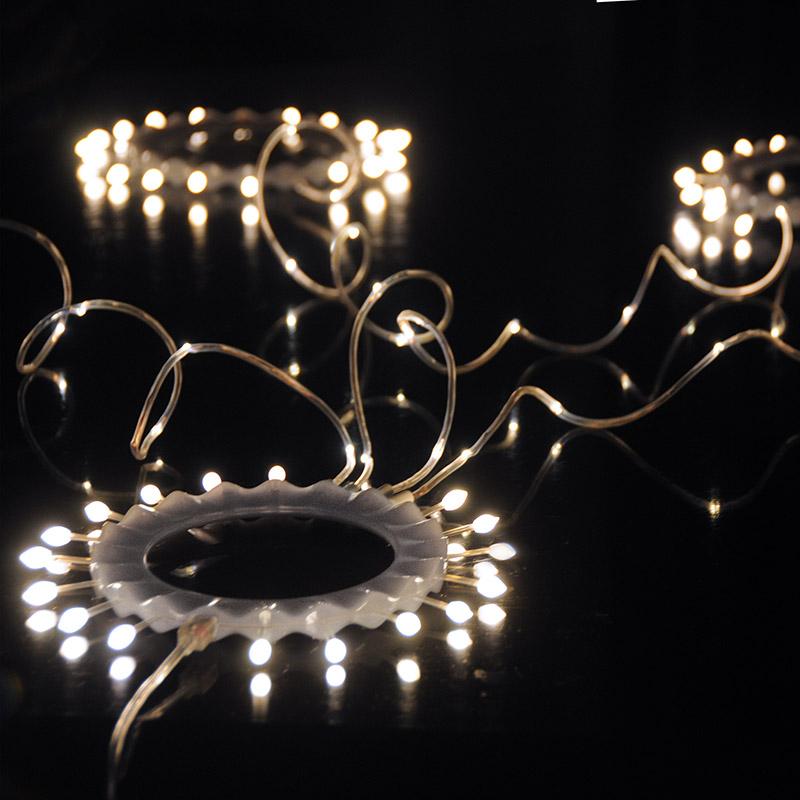 guirlande lumineuse articulée en forme de couronne allumée posée sur un fond noir - tsé tsé