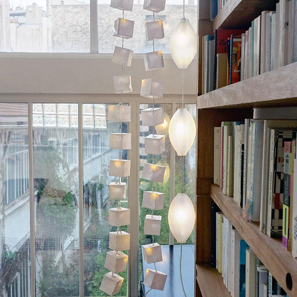 lampe suspendue avec des globes en verre et guirlandes cubes en papier devant une fenêtre - tsé tsé