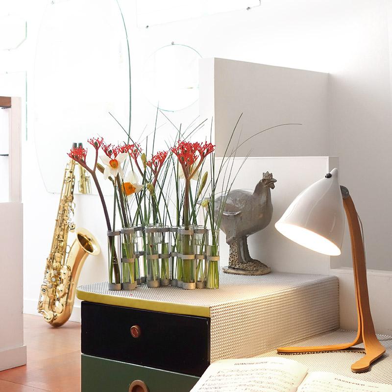 lampe en porcelaine brillante sur pied en bois à côté d'un saxophone et d'un vase d'avril - tsé tsé