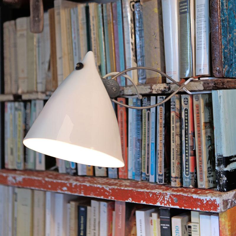 lampe en porcelaine émaillée allumée et fixée à une bibliothèque par une pince - tsé tsé