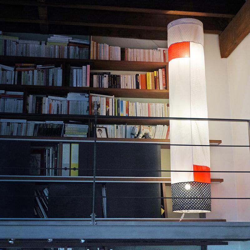 grande lampe en tissu suspendue près d'une bibliothèque - tsé tsé