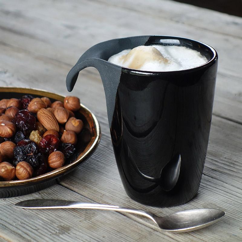 cappuccino dans un un mug noir et assiette de fruits secs - tsé tsé