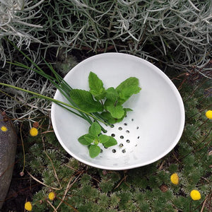 herbes aromatiques dans un bol perforé en porcelaine blanche - tsé tsé