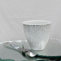 tasse blanche en porcelaine avec des petits pois argentés posée sur un miroir - tsé tsé
