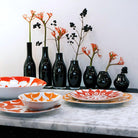petits vases noirs sur table avec vaisselle ouzbek colorée - tsé tsé