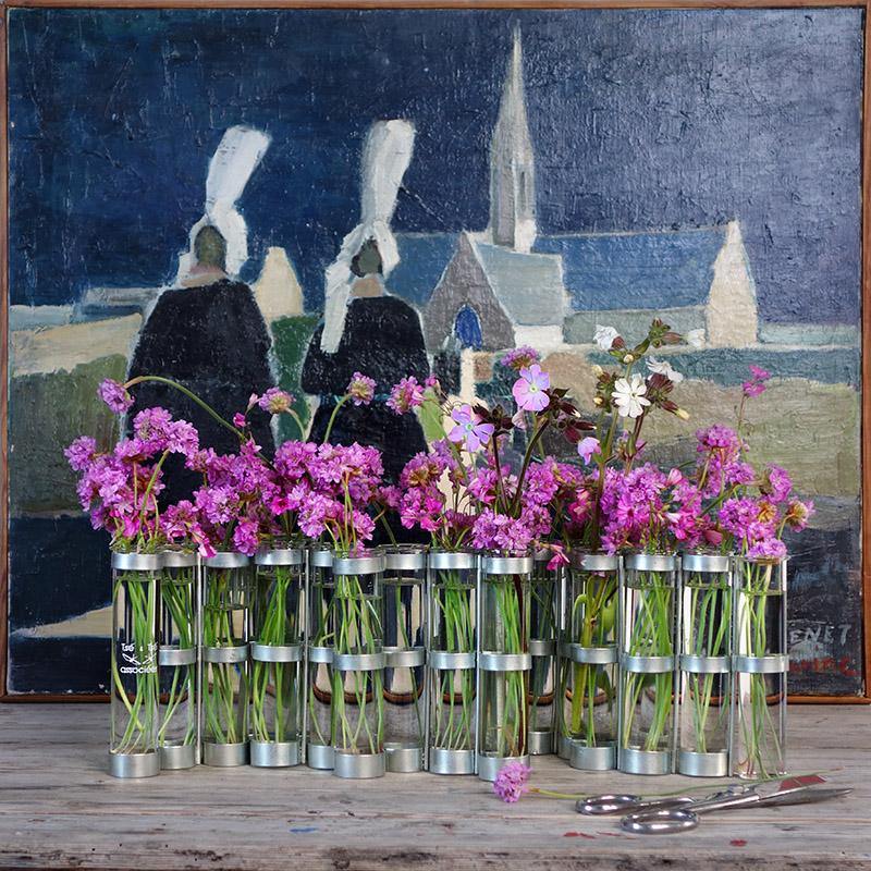bouquet de petites fleurs roses dans le petit modèle du vase d'avril posé devant un tableau - tsé tsé