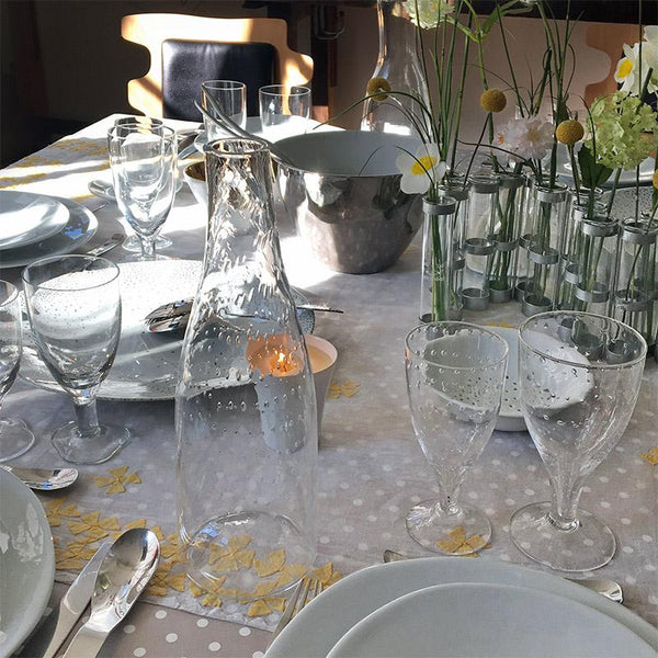table dressée avec des verres à pieds et une carafe à petites bulles d'air - tsé tsé
